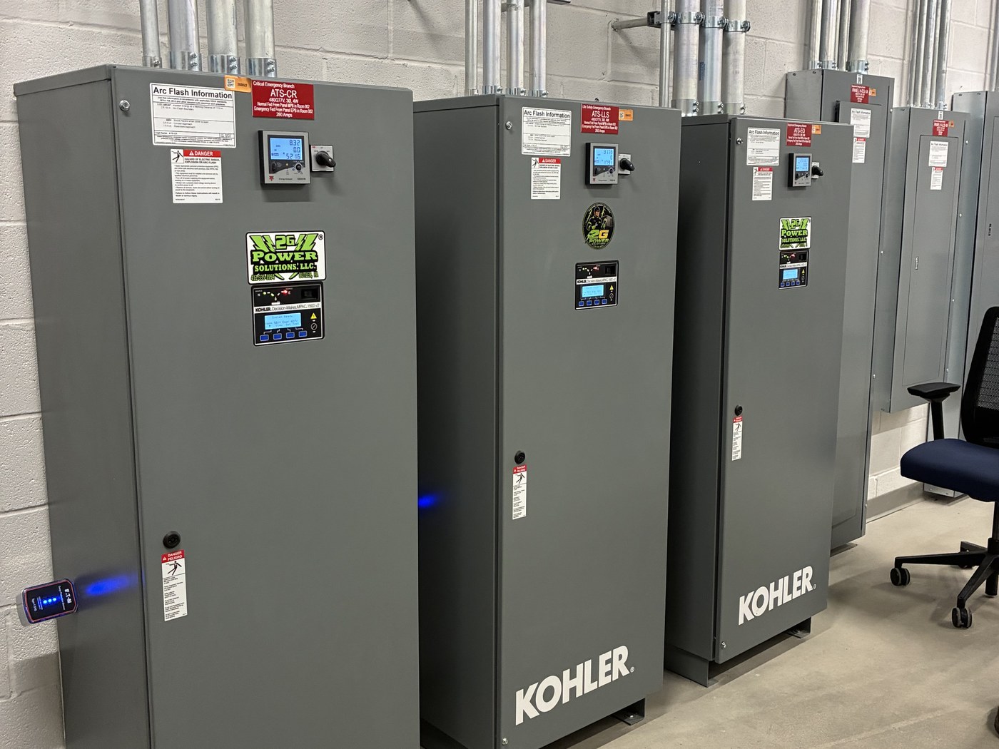 A lineup of Kohler automatic transfer switches at a commercial standby-power installation serviced by 2G Power Solutions