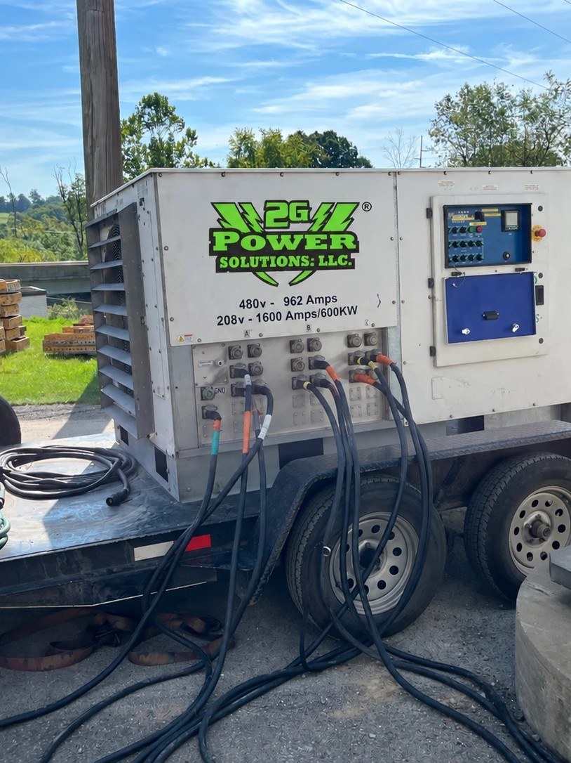 A 2G Power Solutions load bank unit rated 480V/962A and 208V/600KW, connected with heavy test cables on a trailer for commercial generator load-bank testing