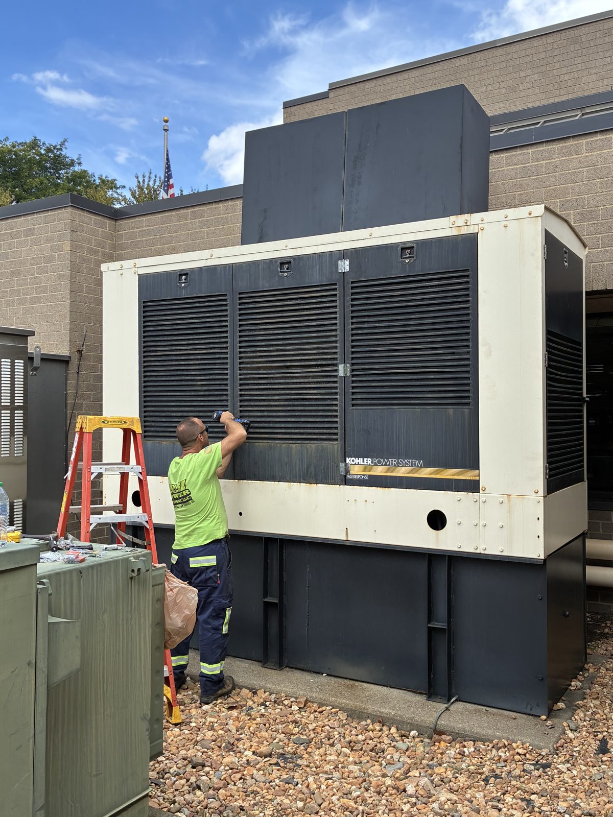 A 2G Power Solutions technician servicing a large commercial standby generator
