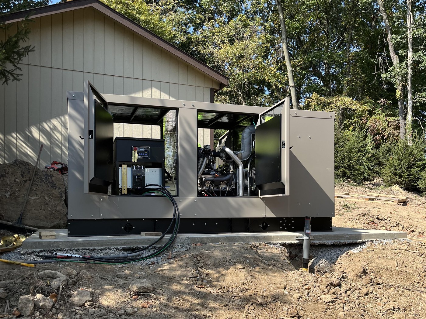 A residential standby generator being installed on a concrete pad beside a home by 2G Power Solutions