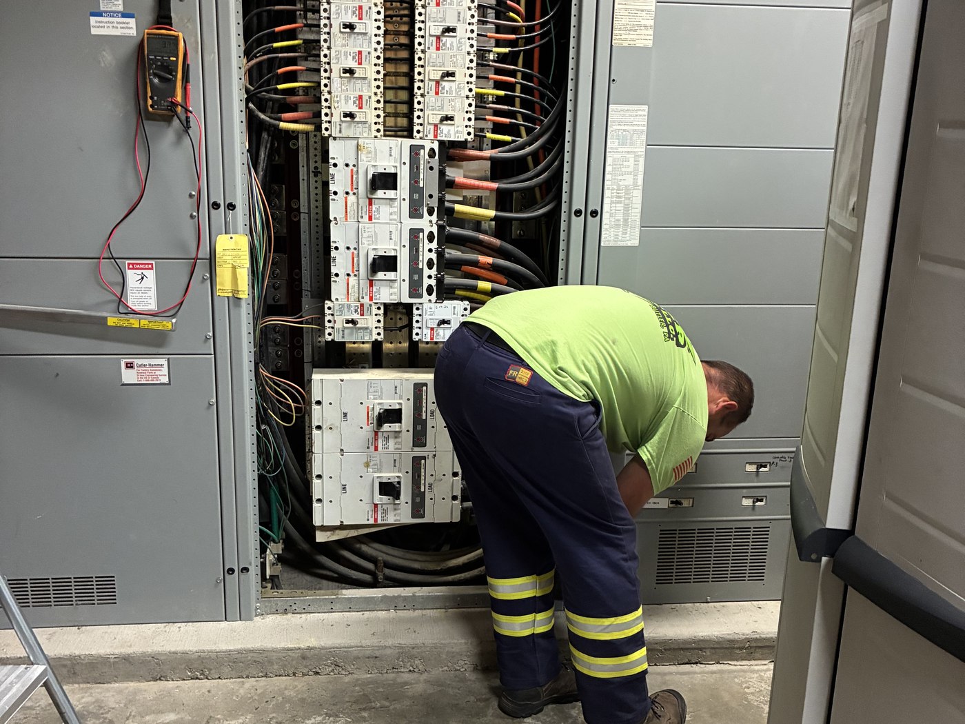 A 2G Power Solutions technician servicing an open commercial switchgear panel