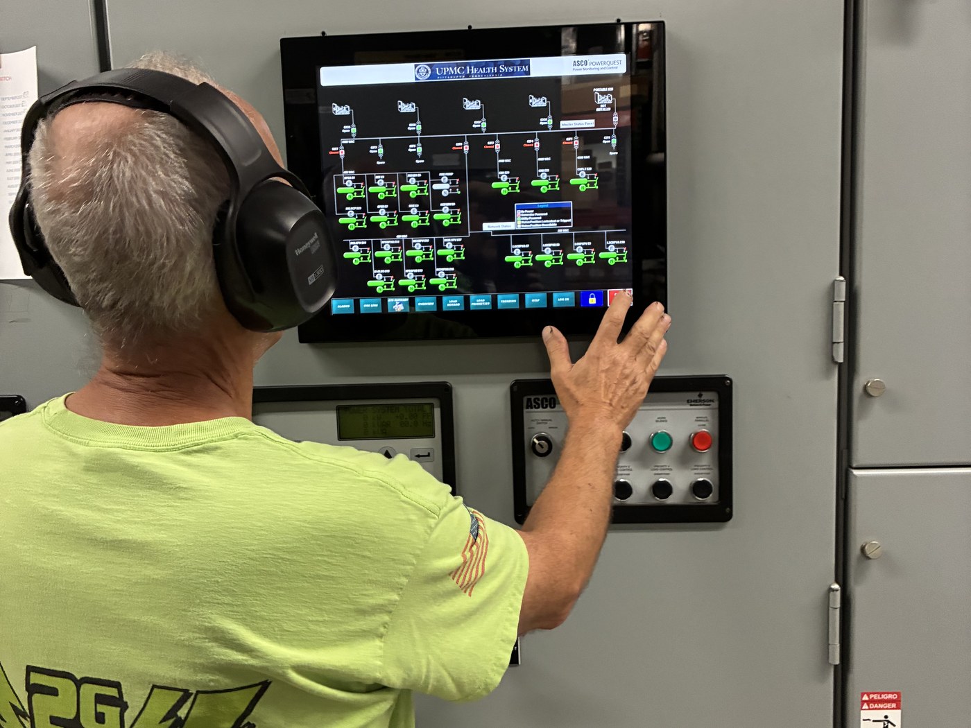 A 2G Power Solutions technician operating a switchgear control panel at a commercial standby-power installation